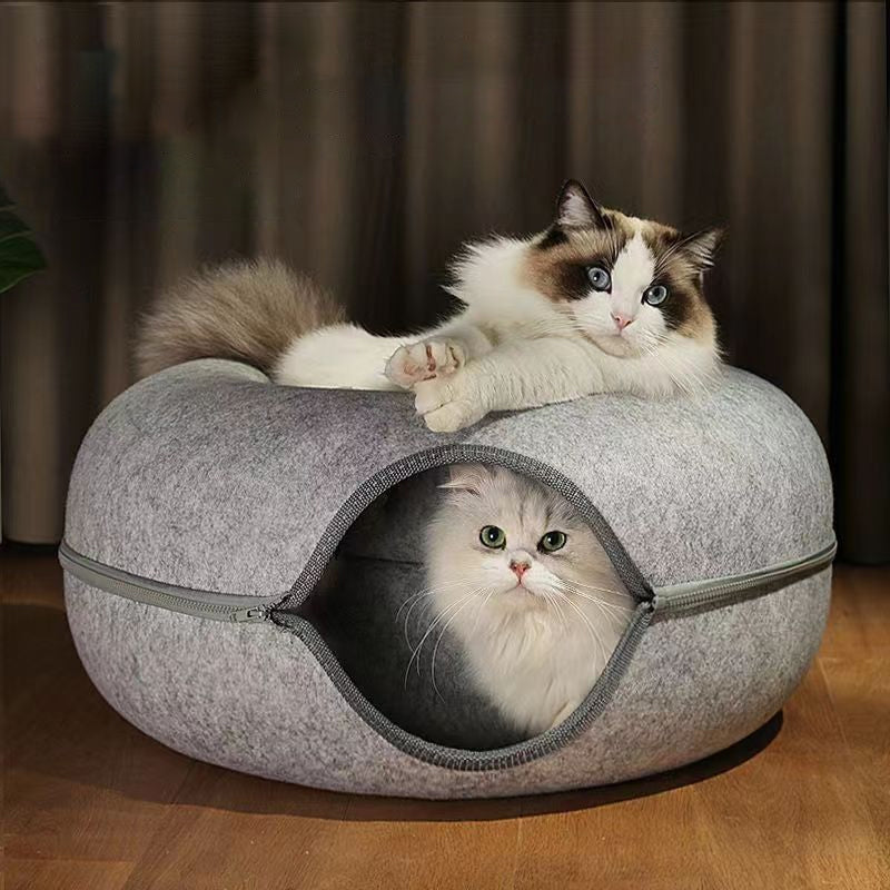 Fluffy cat relaxing in the felt donut cave
