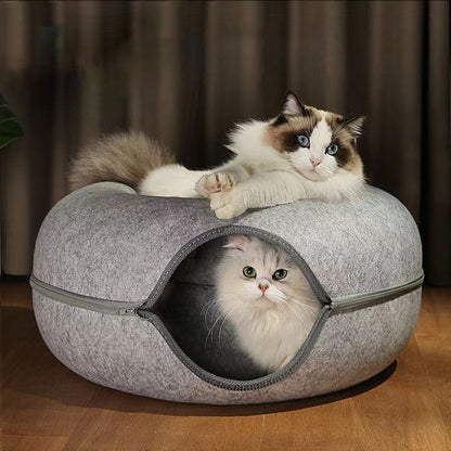 Fluffy cat relaxing in the felt donut cave